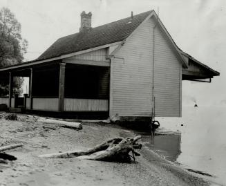 Foundations of this boarded-up island house were washed away by lake