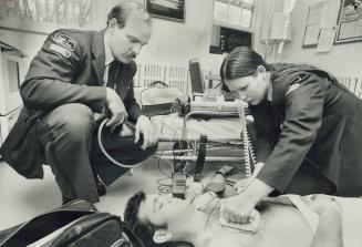 How it's done: Ambulance paramedica Bruce Polley, Debbie Pleasance practise Polley, Debbie Pleasance practise life-saving heart techniques on colleague Lloyd Legate