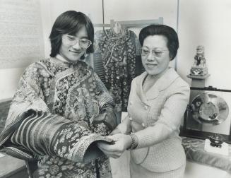 Frank sun, 22, models a Chinese ceremonial robe on display at the Hong Kong pavilion of Caravan '72