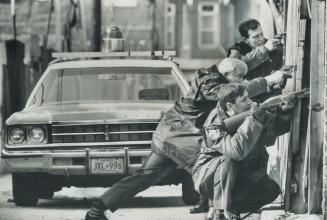 Tense police constables train their weapons on rear windows of house on Brunswick Ave