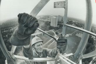 Syl Brothers works on top of the controversial police communications tower in Sir Winston Churchill park, on Spadina Rd