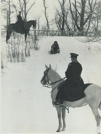 Mounted Metro P. C.s Jim Davis and John Wear make a protective check on young children sliding on the hills. The youngsters are attracted to the innum(...)