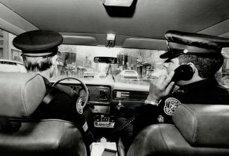 Pursuit car: Sgt. Donald Caisse keeps in contact by radiophone with headquartes while Sgt. John Mann drives the pursuit cruiser - often at high speeds(...)