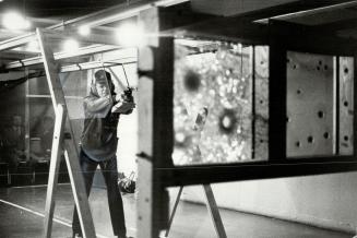 Mangum force. Staff Sergeant Reg Devonshire of Metro police fires handgun from distance of 15 feet at bulletproof glass now produced by Canadian Gener(...)