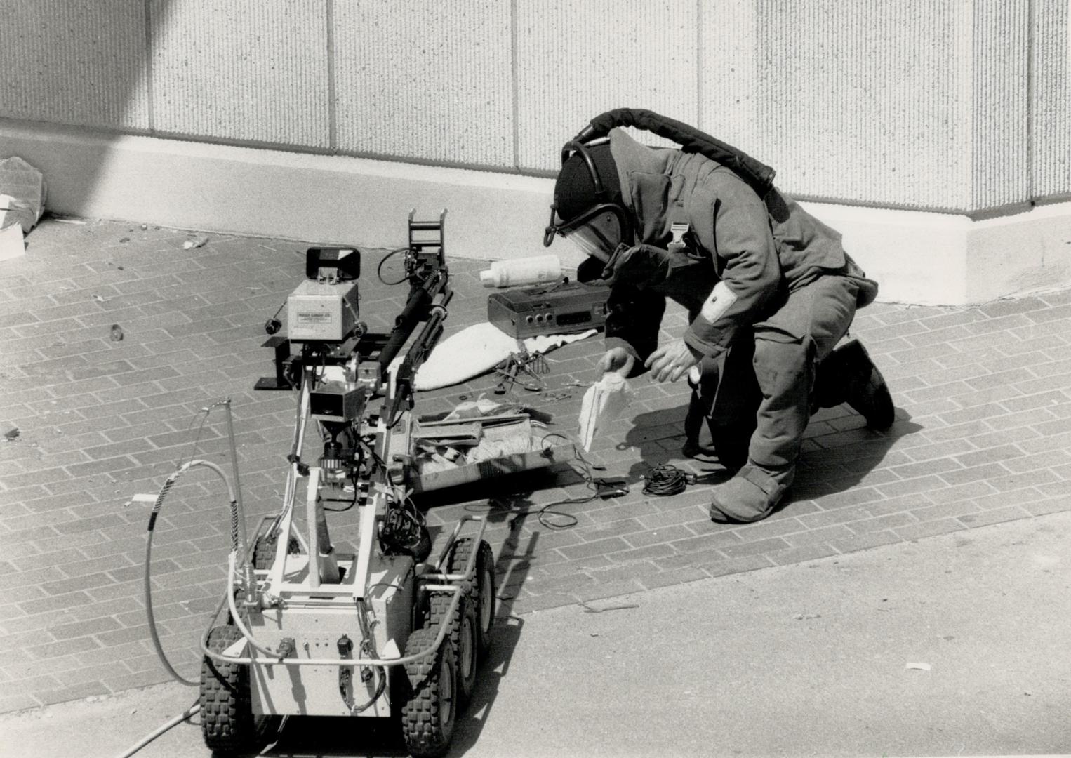 Police examine suitcace 'Bomb' An emergency task force officer examines items in a suitcase that was blown up outside downtown's 52 Division by a robo(...)