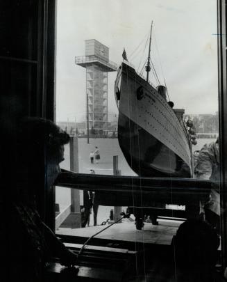 Pulling into port. Workmen ease a model of the famous Atlantic liner Mauretania into the Marine Museum of Upper Canada on the CNE grounds yesterday. T(...)