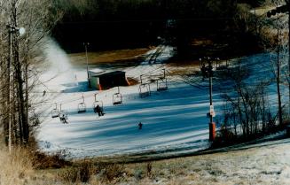 Depicts ski hill and lift, artificial snow.
