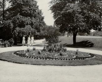 Image shows three ladies walking in the park.