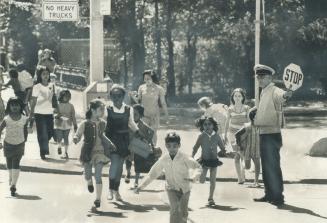 Jim McInerney Shepherds a flock of children across the road to rose Avenue public school