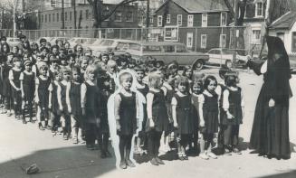 Children line up at St. Paul's separate school, watched by Sister Mary Bernadette. Are they being short-changed on education?