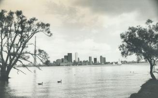 Image shows a lake view with some Harbour buildings in the far background.