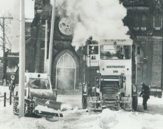 A $140,000 Machine that scoops snow up from the Street, melts it ans spews the water out into the gutter goes into action yesterday on Adelaide St. W.(...)
