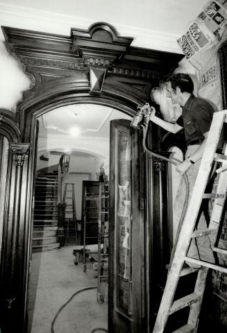 Touch of class: Mahogany stain for the hand-carved moldings is being sprayed on by furniture refinisher Larry Keavey as part of the restoration work on Humewood II