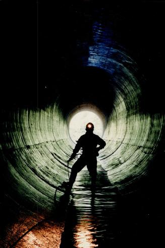 Bonie Bertumen stands in a 12-foot sewer, one of the many running below Metro