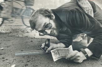 Clutching his $100 prize for winning The Star's Celebrity Pothole Contest, Jim Diamond checks road level