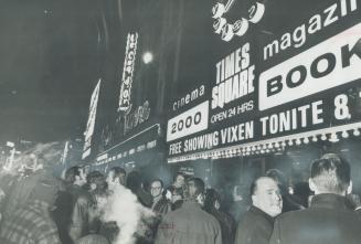 Crowd of men congregate in front of building with large sign reading, Times Square Open 24 hrs  ...