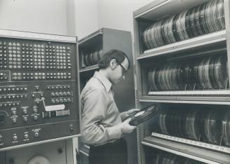 These computer tapes being filed at Metro police headquarters by Vern MacIldoon are a vital aid in synchronizing stoplights and controlling traffic fl(...)