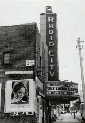Marquee sign; vertical section reads Radio City; billboard section below reads, Bobby Solo Una  ...