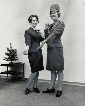 New TTC Uniforms. New uniform for Toronto Transit Commission gudes, shown by Margaret Harney (right), is strawberry color. Present one, modelled by Marlene Bennett, is maroon