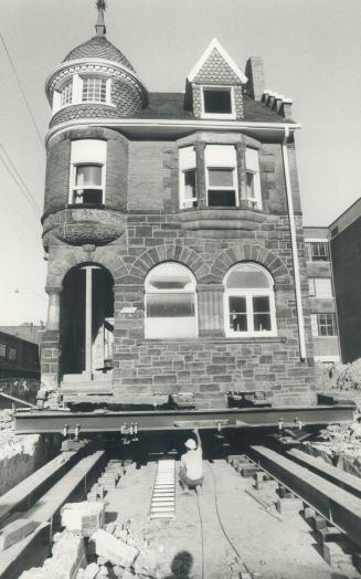Moving day at U of T. Right on track for its new home, Bancroft Hall is winched along on steel pipes to a location about 50 feet back from its site ne(...)