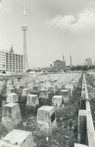 Image shows some remaining construction pieces with a CN Tower in the background.