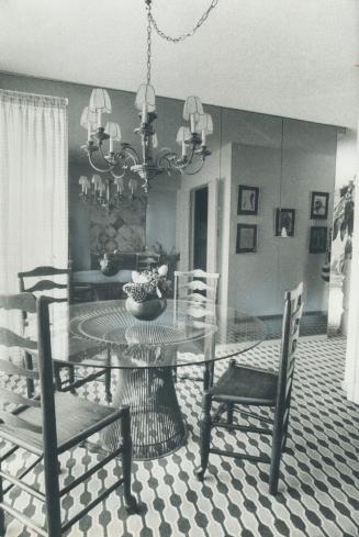 Image shows an interior of the room with a table and four chairs around it.