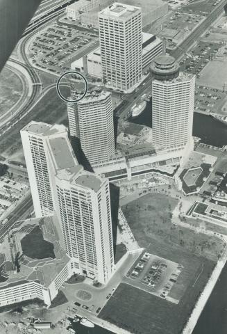 Image shows an aerial view of a few high-rise waterfront buildings.