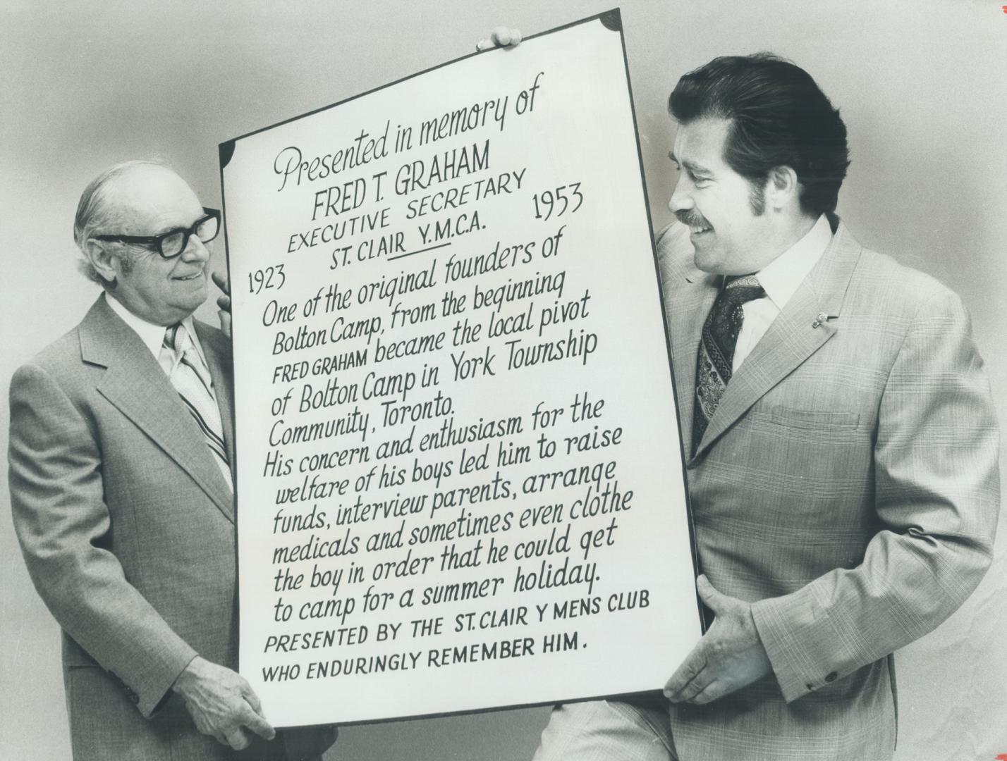 A memorial plaque in honor of Fred Graham, a founder of the United Way's Bolton Camp for small children and their mothers, is held by George Radford, (...)