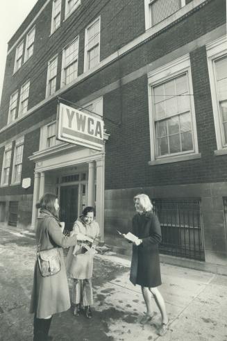 Anne Baulch, left, hands leaflets on new YWCA housing project to Cionie Fuentebella, centre, and Helen Gough