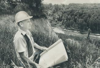 R. W. Hannaford, site superintendent at Metro's new zoo, surveys a valley that will be part of the route of a three-mile transportation system for vis(...)