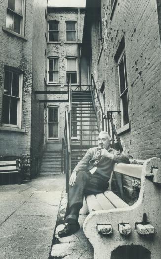 The courtyard of Laughlen Lodge provides a place for Clarence Webster, 73, to puff on his pipe