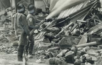 Abandoned dolls: Fireman, standing in front of dolls from a destroyed toy store, hose down the ruins of Mexico City's Regis Hotel, where 200 people are believed trapped