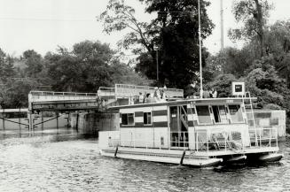 Family on houseboat leaves lock on leisurely 200 km journey meandering through Rideau canal system in eastern Ontario