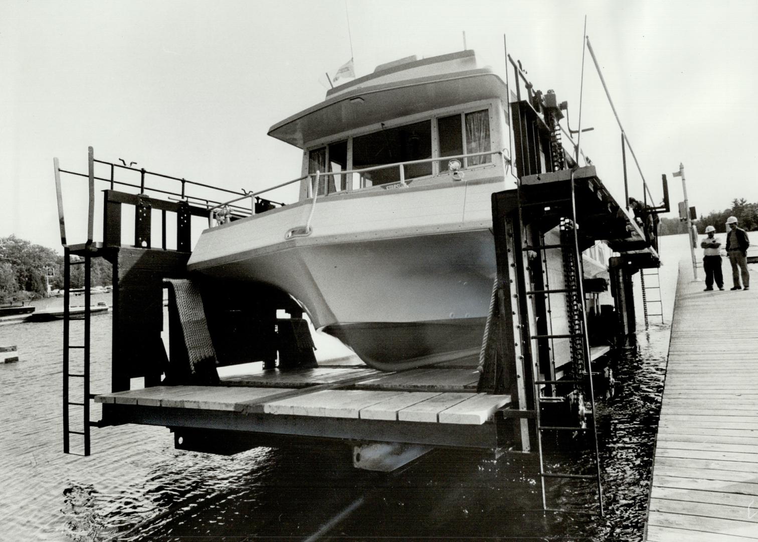 It's a squeeze as Starship is loaded aboard the rail car at Big Chute on the Trent Canal system with just a quarter of a inch to spare on each side. [Incomplete]