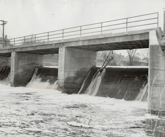 Punt being paddled by three boys was carried over the falls at this dam on the Credit river at Georgetown, throwing all three into the deep, fast-flowing water of river