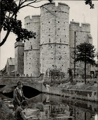 Ancient westgate towers form a peaceful setting in the heart of busy Canterbury, Kent, when these English youngsters were photographed fishing for min(...)