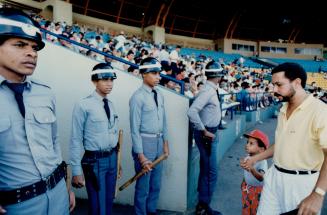 An unfamiliar aspect of a visit to the ballpark in the Dominican is the presence of steel-helmeted soldiers