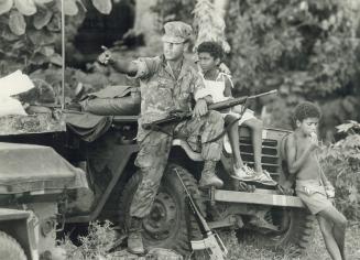 Friendly invader: U.S. soldier takes time out to chat with two Grenadian children during joint U.S.-Caribbean nations' invasion of Grenada last week. (...)