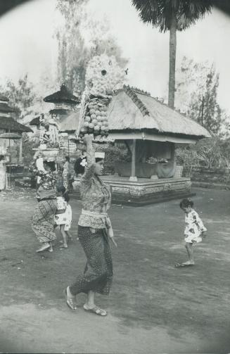 A Balinese woman carries her offering to one of 10,000 temples
