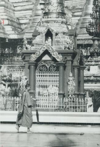 A buddhist monk carries his umbrella, a reminder of the long British occupation of Burma, as he strides the terrance of one of the world's great relig(...)