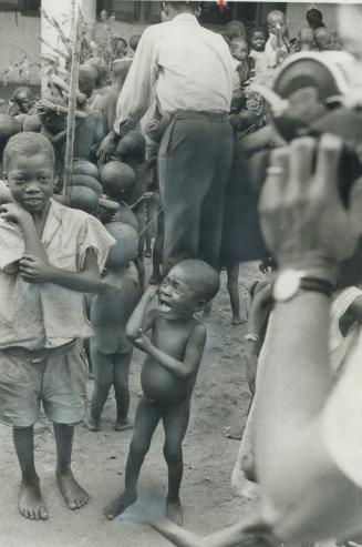 A child cries as another grins at a Port Harcourt food station on the Nigerian coats