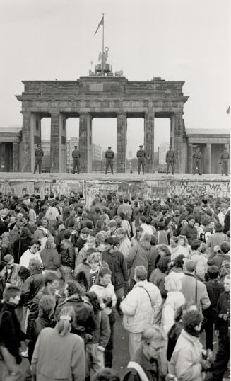 Berlin, Nov. 10: With the news that the berlin Wall was about to open, West Berliners gathered in view of the Brandenburg Gate under the gaze of East German police atop the wall