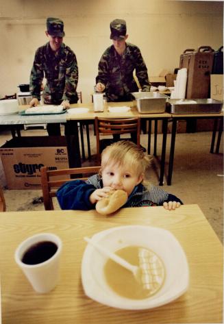 Melanie Greutkzy, 2, from East Germany eats a roll and soup in Marion field refugee camp's soup kitchen, run by the Berlin Brigade from the U.S. Army (...)