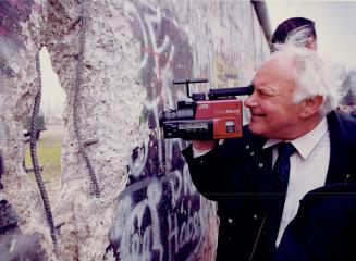 Home movies: A West German records history on film as he takes some shots of East Berlin through a hole in the Berlin Wall