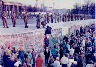 A west German protestor tries to talk with East German soldiers who are occupying the Berlin Wall November 11