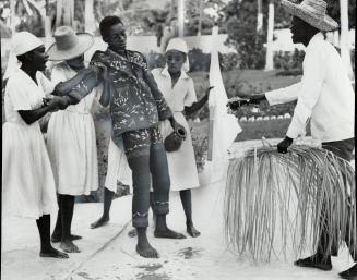 In a trance, a man reels and slumps during a voodoo dance in Haiti