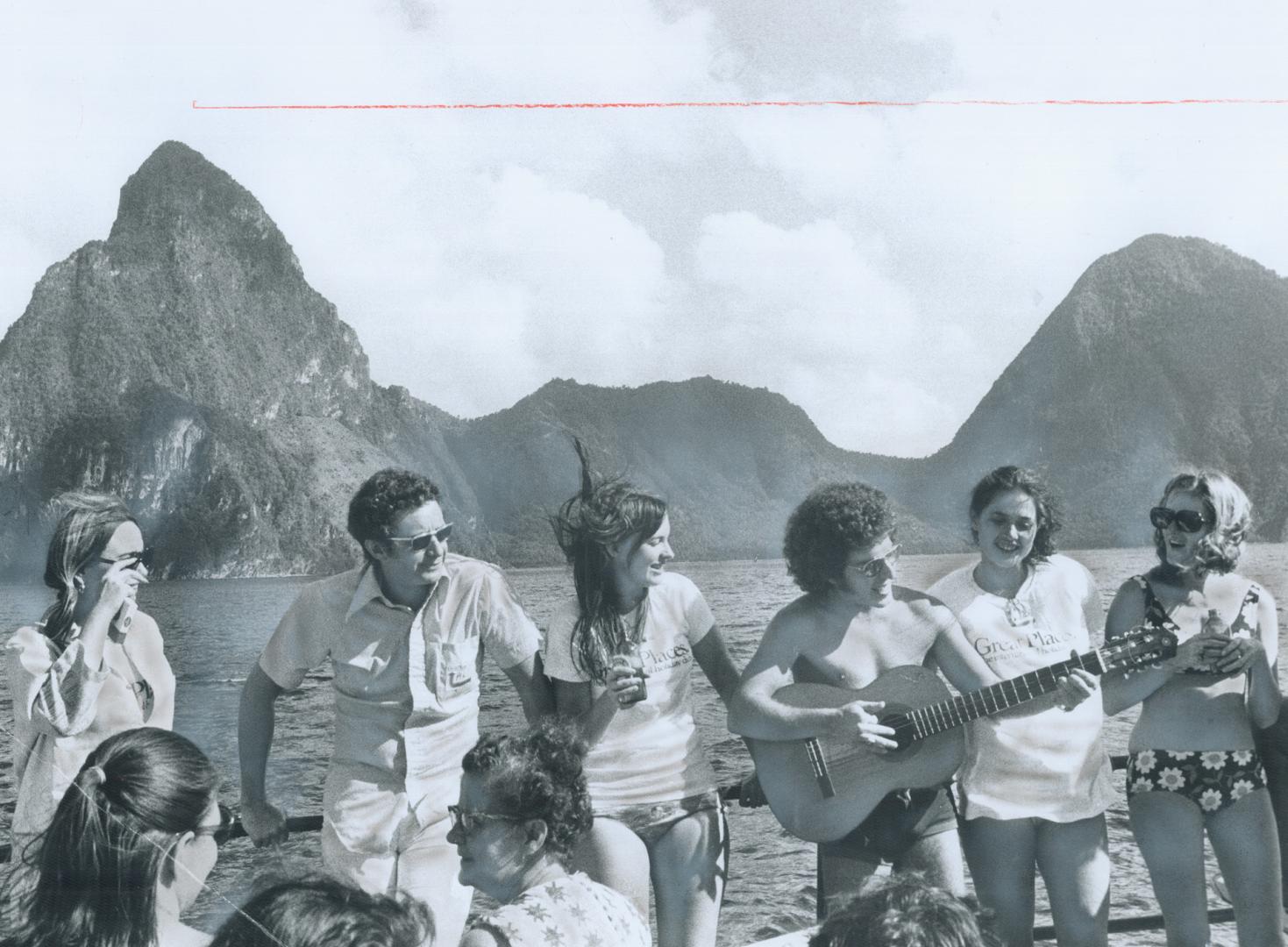 Sailing Off St. Lucia, a group of tourists from Toronto pass the twin peaks of the Pitons, which guard the island's drive-in volcano, Soufriere. Playi(...)