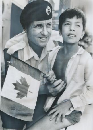 In Saigon with the Canadian peacekeeping team, Warrant Officer Al Scott, 49, of Oakville holds a small boy waving a Canadian flag. Scott, born in Lond(...)