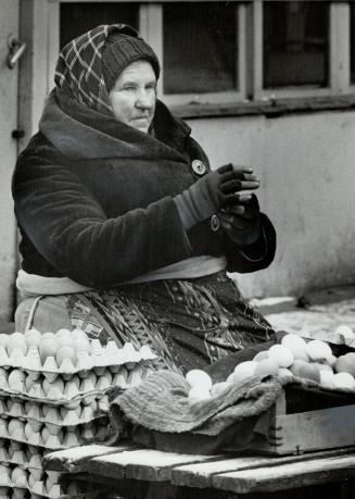 The egg lady: A woman egg seller huddles in the bitter cold of the Old Praga marketplace, sorting, cleaning and counting her eggs