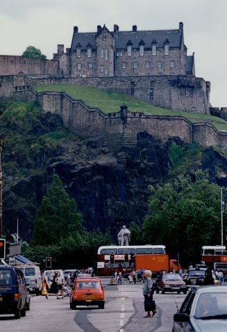 The grim bulk of Edinburgh Castle, seen from the city, top, and at the changing of the guard, below, offers visitors 800 years of drama